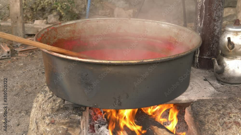 The tomato sauce made with traditional methods in Turkey. Natural, additive-free. in a copper pot. It is boiling over wood fire. 4K The tomato sauce made with traditional methods in Turkey. Natural, additive-free. in a copper pot. It is boiling over wood fire. 4K