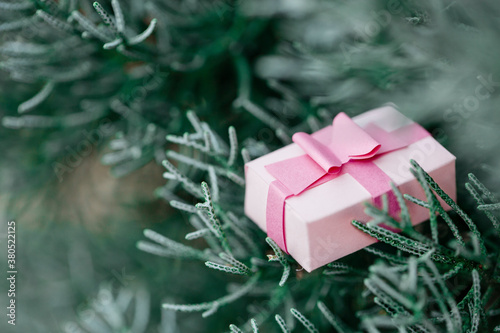 Little pink gift box decoration with ribbon on a Christmas tree photo