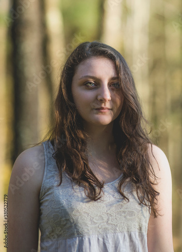 A young woman in the woods with sunlight on her face photo