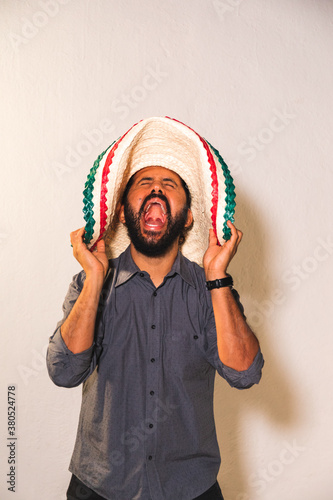 Retrato de hombre joven mexicano hispano latino con sombrero gritando con felicidad emoción dia de la independencia 5 de mayo photo