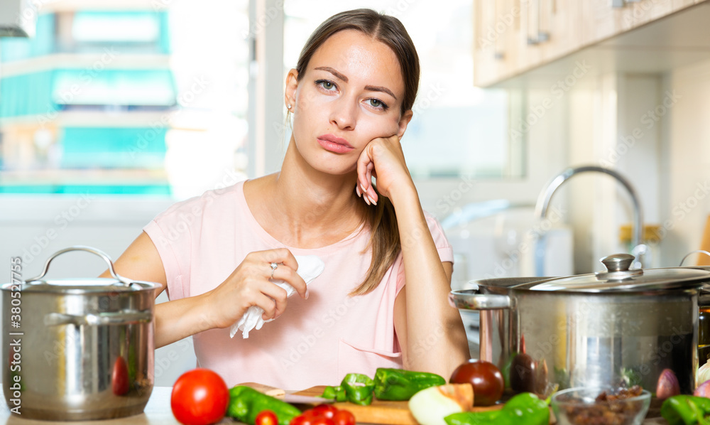 Upset housewife trying to cook vegetable soup at kitchen
