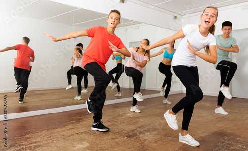 Teenage dancers practicing active vigorous dance in modern studio..