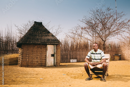 African Hambukushu Man in front of his hut photo