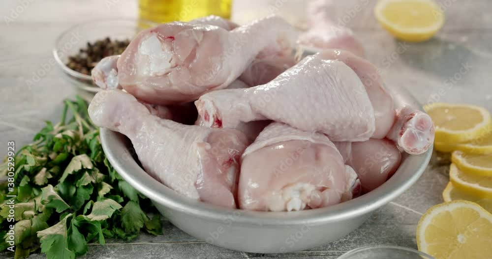 Raw chicken drumstick with lemon slices and spices rotate. Raw chicken drumstick with lemon slices and spices rotate.