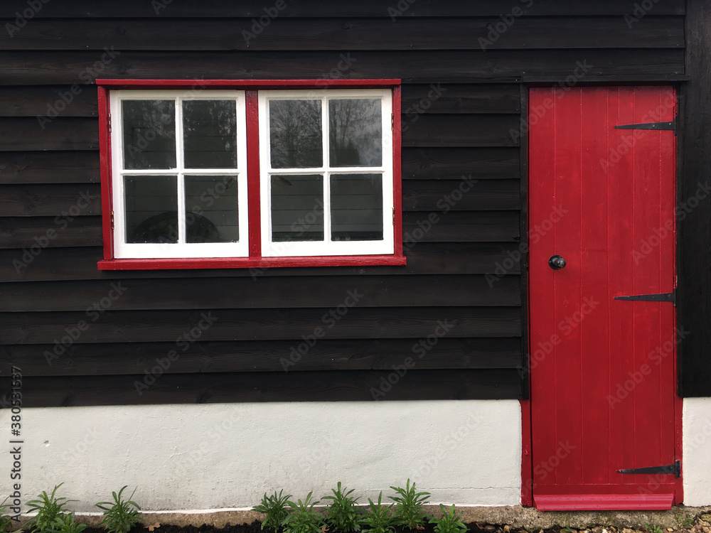 Outbuilding with red door and window frames. Outbuilding with red door and window frames.