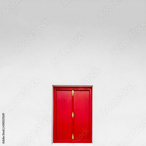 Red door with white wall. © ParinPIX