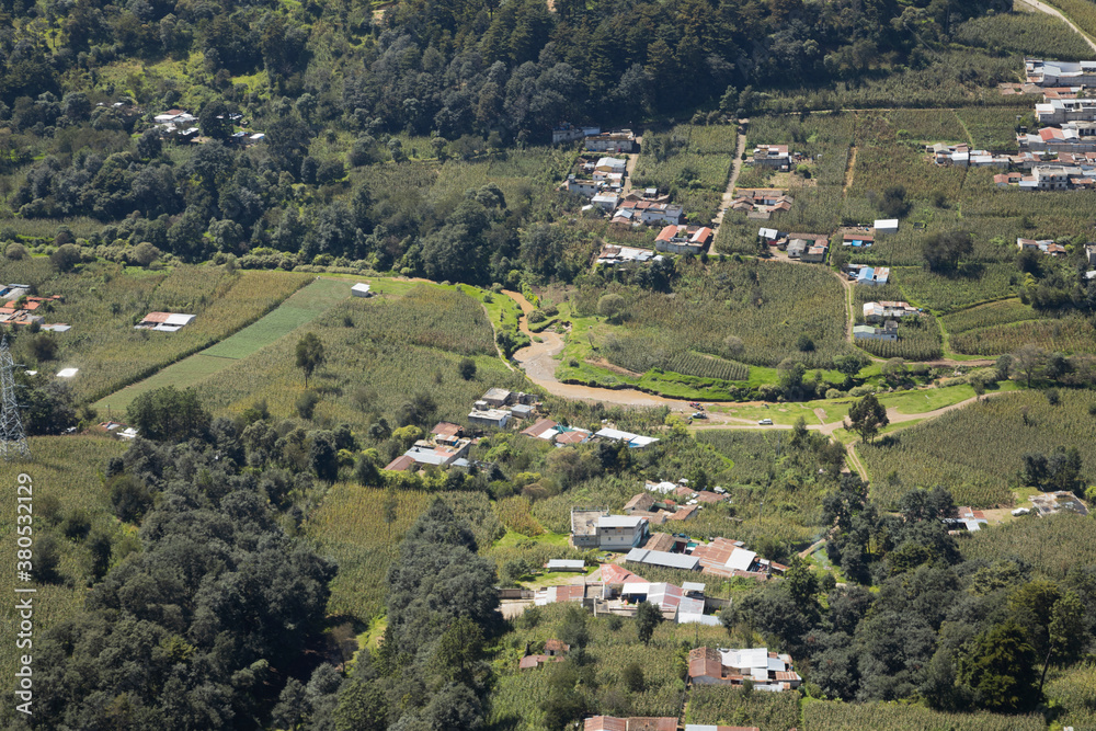 Small town surrounded by trees and crops seen from above - Beautiful aerial photo of a natural place from above - Municipality of Olintepeque in Quetzaltenango Guatemala