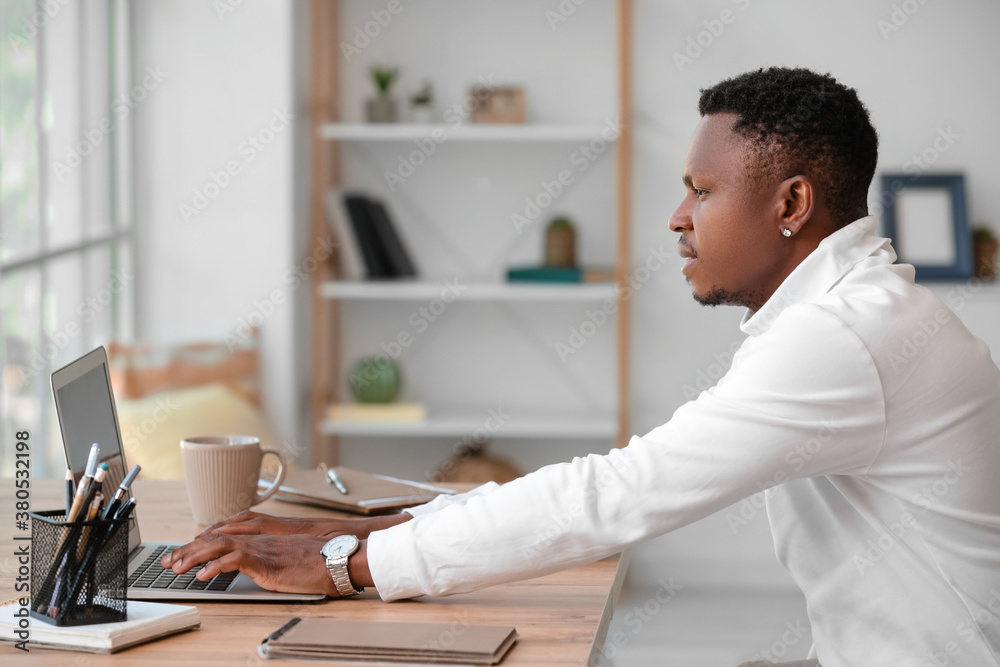 African-American man working on laptop in office African-American man working on laptop in office