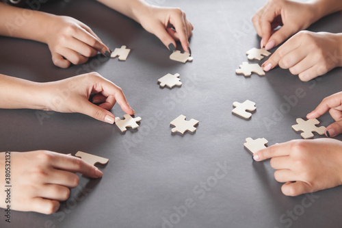 Hands of people holding jigsaw puzzle. Partnership, Success, Teamwork