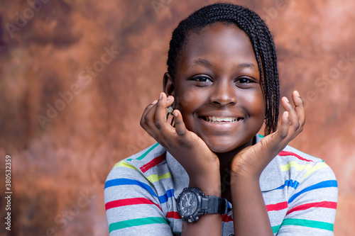 Portrait headshot of a happy/excited African teenage girl on an abstract background.