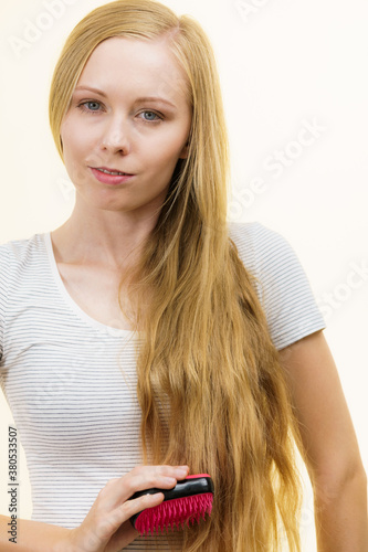 Blonde girl brushing her long hair