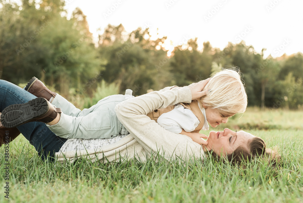 A Mother Laying With Her Young Blonde Son