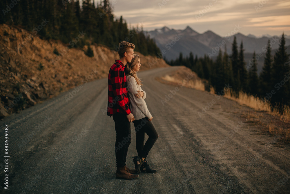 Young engaged couple explore mountain side at sunset Young engaged couple explore mountain side at sunset
