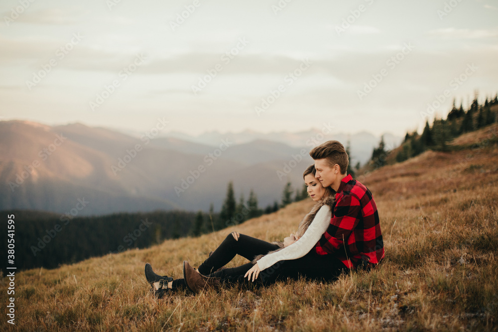 Young engaged couple explore mountain side at sunset Young engaged couple explore mountain side at sunset