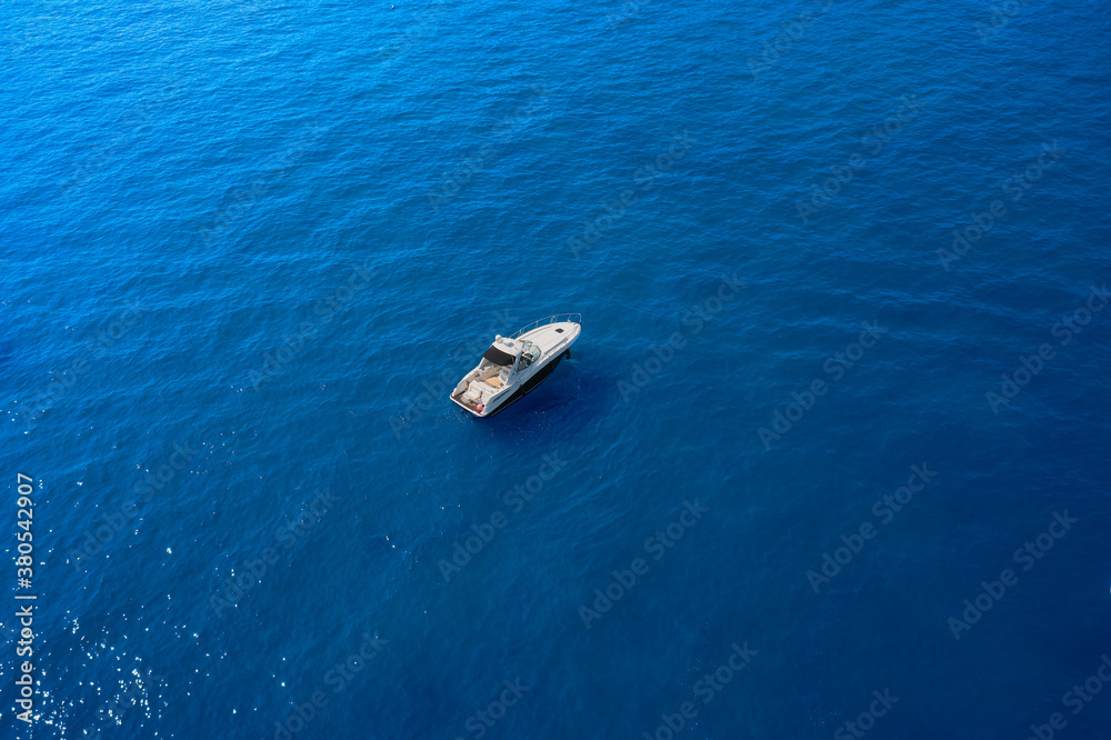 White large yacht anchored anchored on blue water. Travel - image. Yacht in the rays of the sun on blue water.