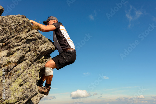 Mountaineering in the Carpathians, a man climbs a rocky peak without protection, alone, amateur mountaineering.