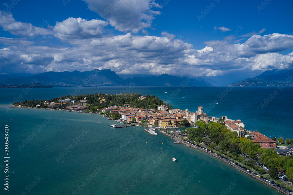 Aerial view on Sirmione sul Garda. Italy, Lombardy. Panoramic view at high altitude. Aerial photography with drone. Cumulus clouds over the island of Sirmione.