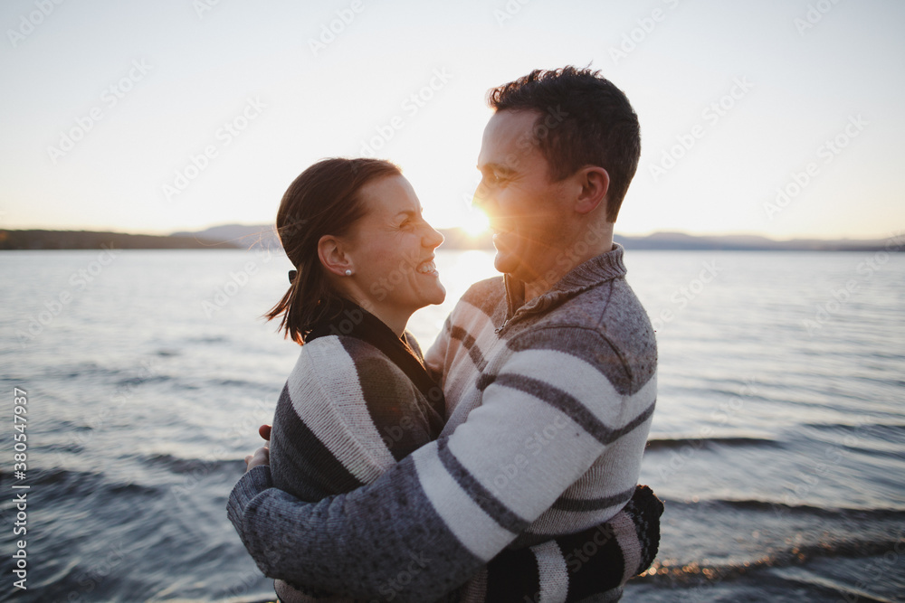 Young happy couple enjoying being together at the beach at sunset Young happy couple enjoying being together at the beach at sunset