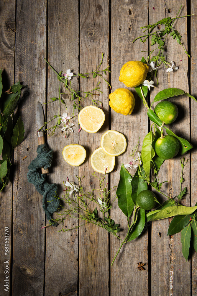 Lemons and limes on an old wood background with a vintage knife and some azahar flowers Lemons and limes on an old wood background with a vintage knife and some azahar flowers