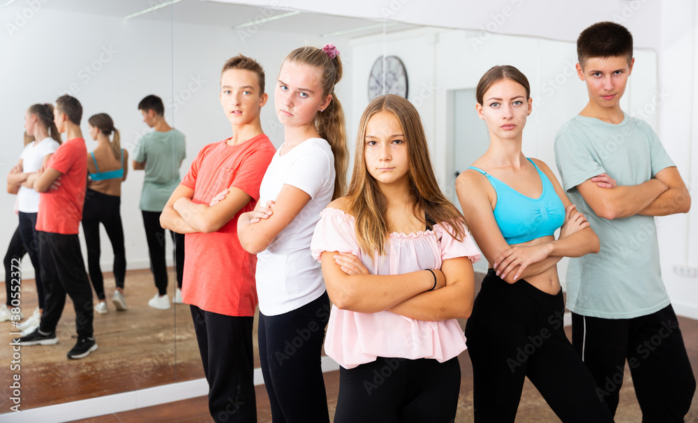 Fototapeta premium Happy teens posing with young female coach during dance training in modern dance school..