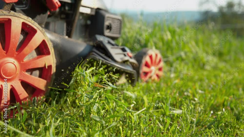 SLOW MOTION, CLOSE UP, LOW ANGLE, COPY SPACE, DOF Motorized lawnmower