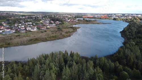 Top view of suburban cottages and houses near a large summer lake