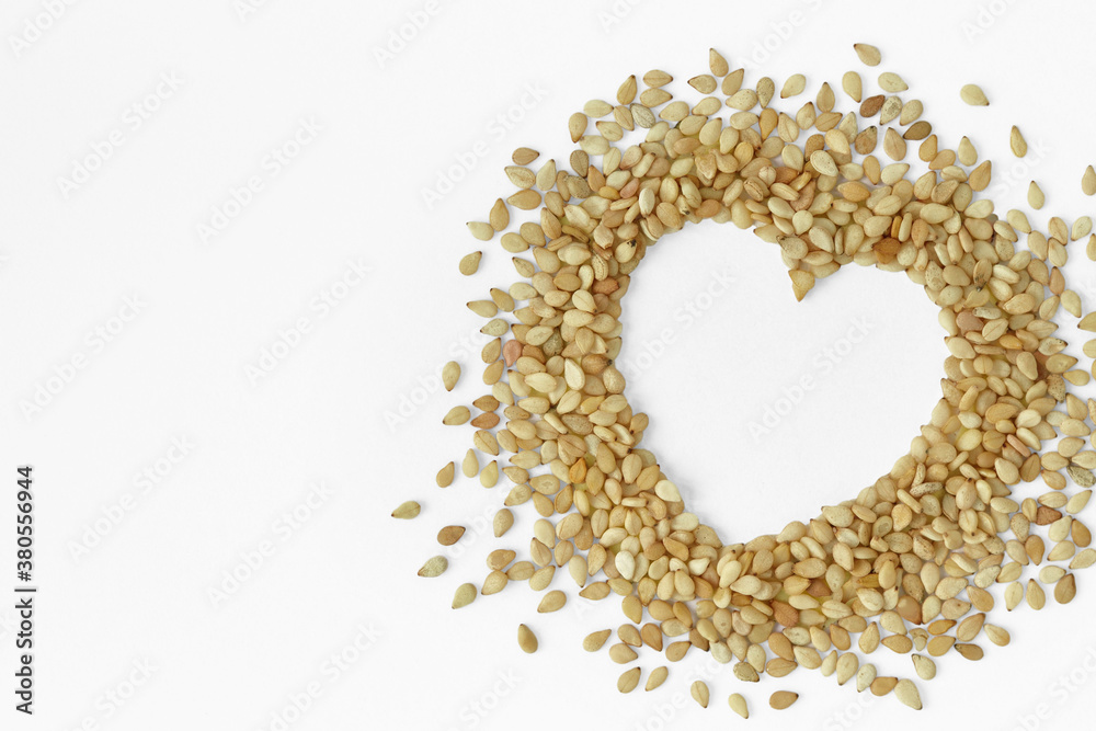 Sesame seeds in the shape of heart on white background - Sesame seeds are good for heart healthy Sesame seeds in the shape of heart on white background - Sesame seeds are good for heart healthy