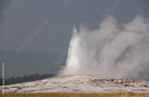 Old Faithful Yellowstone Park. Geyser in Wyoming.Geyser eruption. Cloudy.