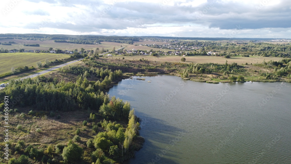 A view from a height of a beautiful calm shore of a forest lake A view from a height of a beautiful calm shore of a forest lake