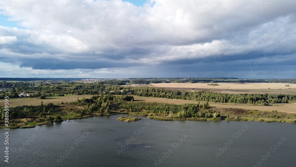 A view from a height of a beautiful calm shore of a forest lake A view from a height of a beautiful calm shore of a forest lake
