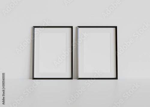 Fototapeta Naklejka Na Ścianę i Meble -  Two black frames leaning on white floor in interior mockup. Template of pictures framed on a wall 3D rendering