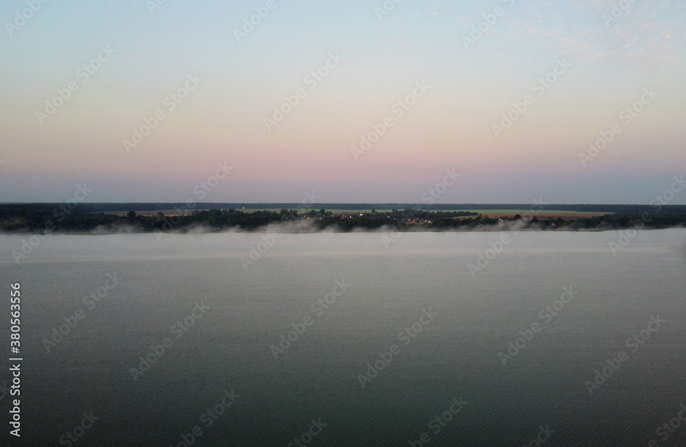 Top view at sunrise on a calm lake and forest