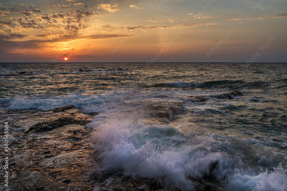 Wilde Brandung eines Meeres an einer felsigen Küste bei Sonnenaufgang