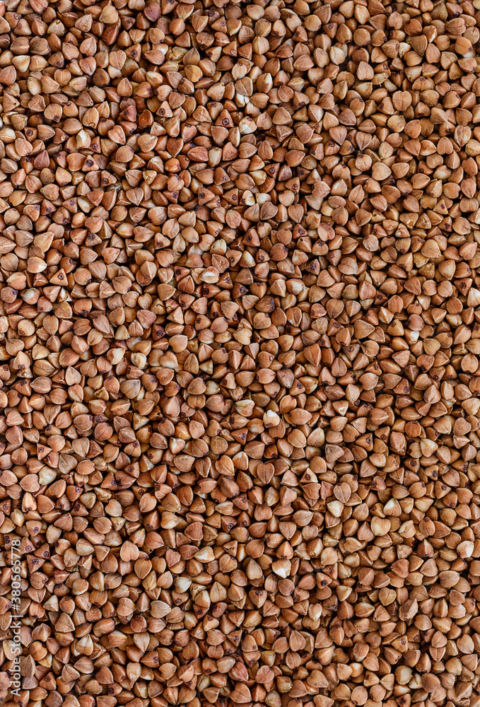 vertical texture of raw buckwheat, brown food background vertical texture of raw buckwheat, brown food background