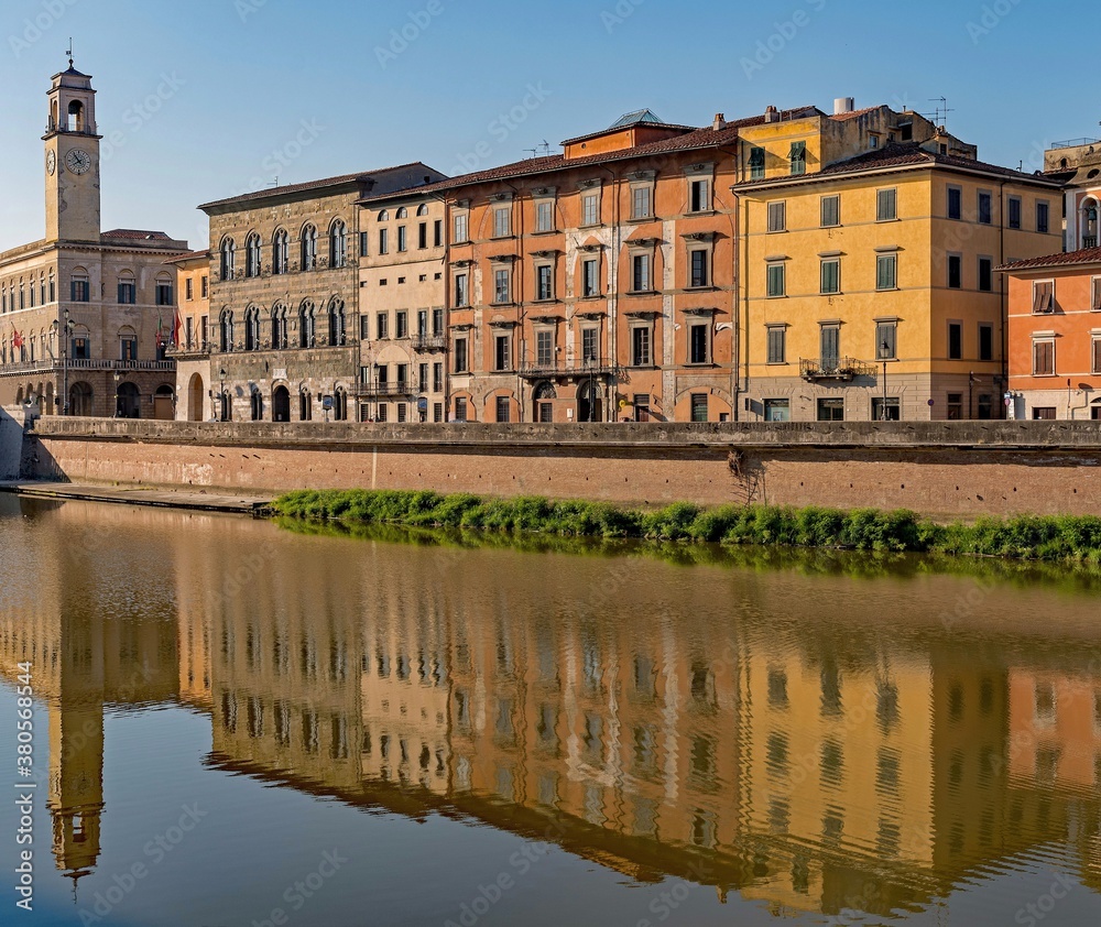 Buildings reflecting at the Arno River at the old town of Pisa, Tuscany Region in Italy
