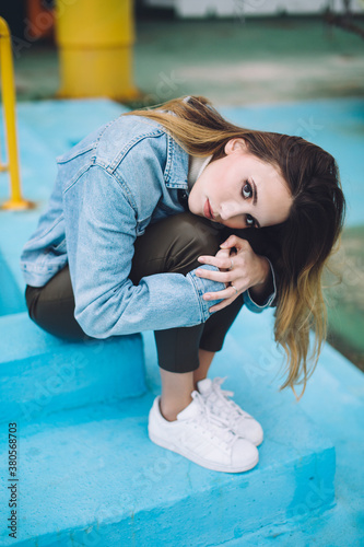 Young pretty woman dressed in 90s near abandoned swimming pool relaxining photo