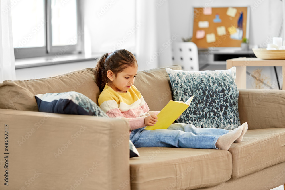 childhood and leisure concept - little girl reading book at home childhood and leisure concept - little girl reading book at home