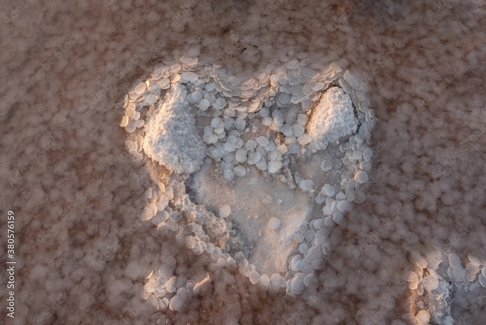 Heart shape made of salt crystals in the water of the estuary. Full frame white abstract background of white crystals of salt. Love concept for Valentines Heart shape made of salt crystals in the water of the estuary. Full frame white abstract background of white crystals of salt. Love concept for Valentines