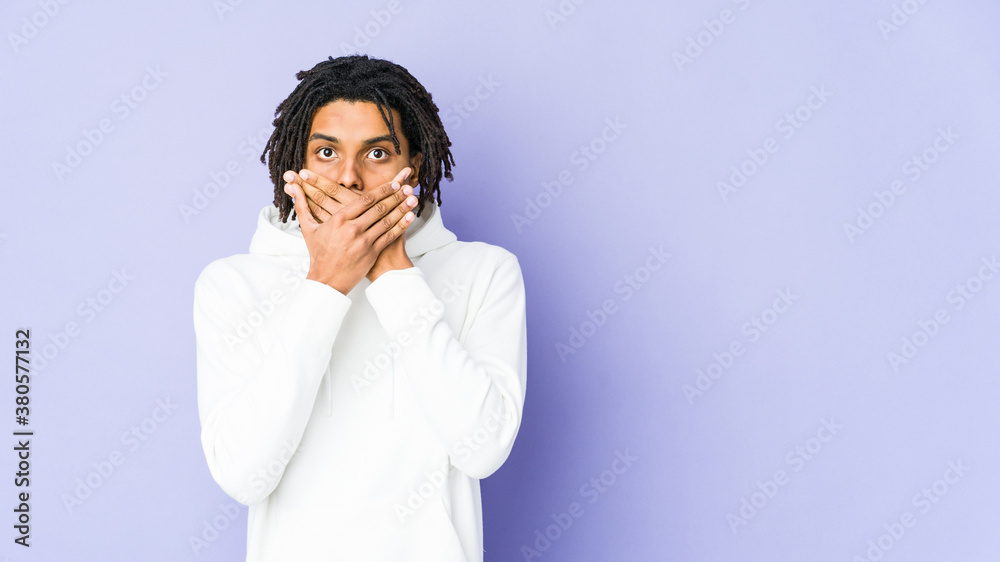 Young african american rasta man shocked covering mouth with hands. Young african american rasta man shocked covering mouth with hands.
