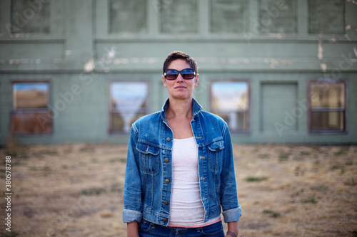 Woman with short hair rocks a denim jacket and sunglasses photo