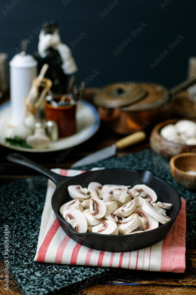 Sliced mushrooms in a cast iron frying pan, ready to be cooked. Sliced mushrooms in a cast iron frying pan, ready to be cooked.