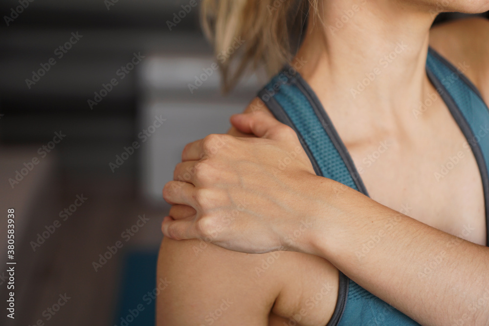 Closeup on fitness woman having pain in shoulder. Pain after home workout Closeup on fitness woman having pain in shoulder. Pain after home workout