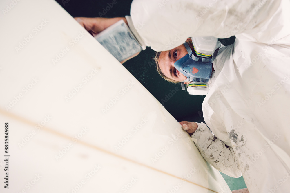 Shaper sanding surfboard