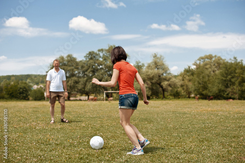Young man and girl are playing soccer