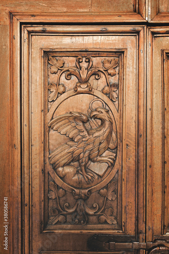 Eagle inlaid on ancient abbey's wooden portal symbolizing John evangelist