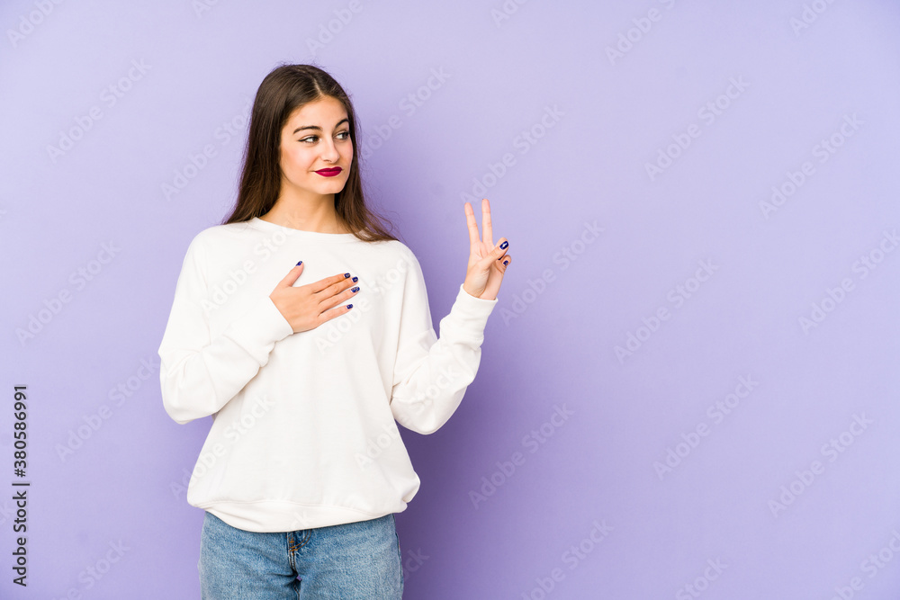 Young caucasian woman isolated on purple background taking an oath, putting hand on chest. Young caucasian woman isolated on purple background taking an oath, putting hand on chest.