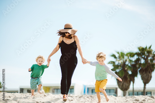 Cute young family running on beach together. photo