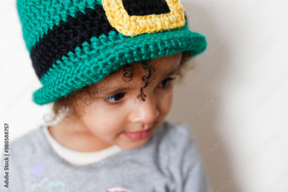 Close up portrait of young girl wearing a handmade crochet leprechaun hat Close up portrait of young girl wearing a handmade crochet leprechaun hat