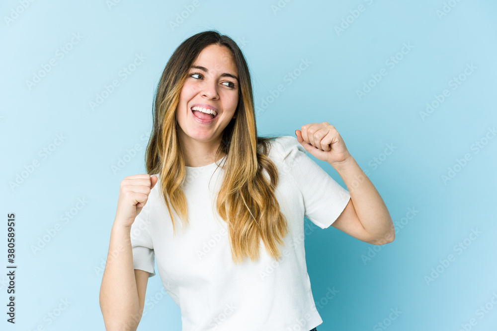 Fototapeta premium Young caucasian woman isolated on blue background dancing and having fun.