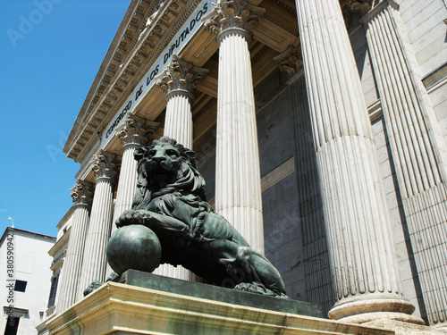 Madrid, Spain, August 19, 2015: One of the cast iron lions on the entrance stairs to the Congress of Deputies. Madrid